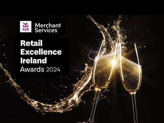 Sparkling Champagne glasses sit beside the Retail Excellence Ireland Awards 2024 logo