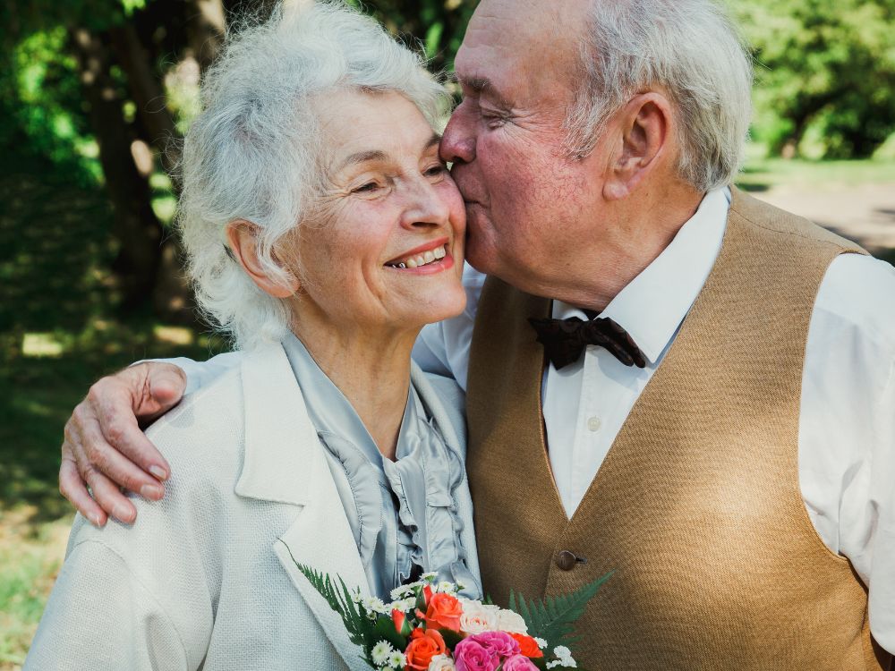 A  man kissing a smiling woman on the cheek