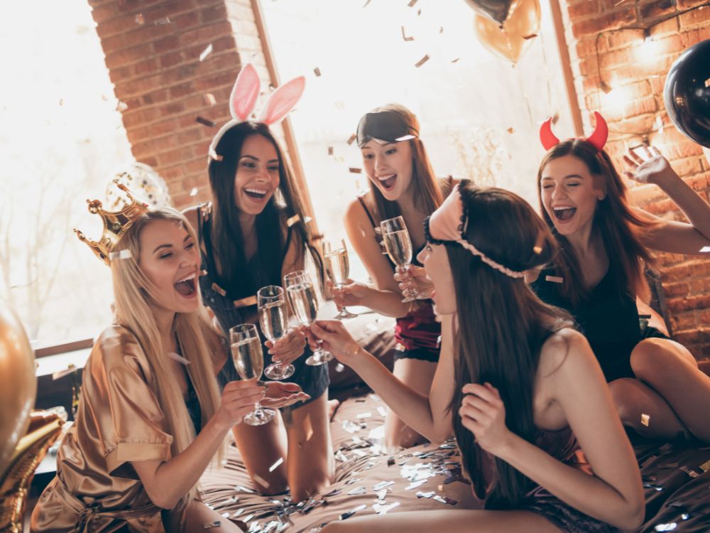 A group of young women laughing and drinking sparkling wine